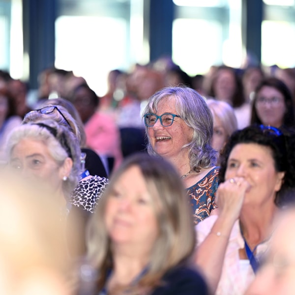 woman smiling in a crowd at a conference